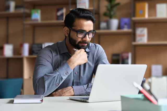 Man looking at computer: Faculty Affairs